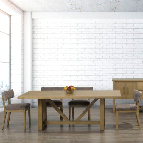 Dining room with wooden table and chairs against a white brick wall.
